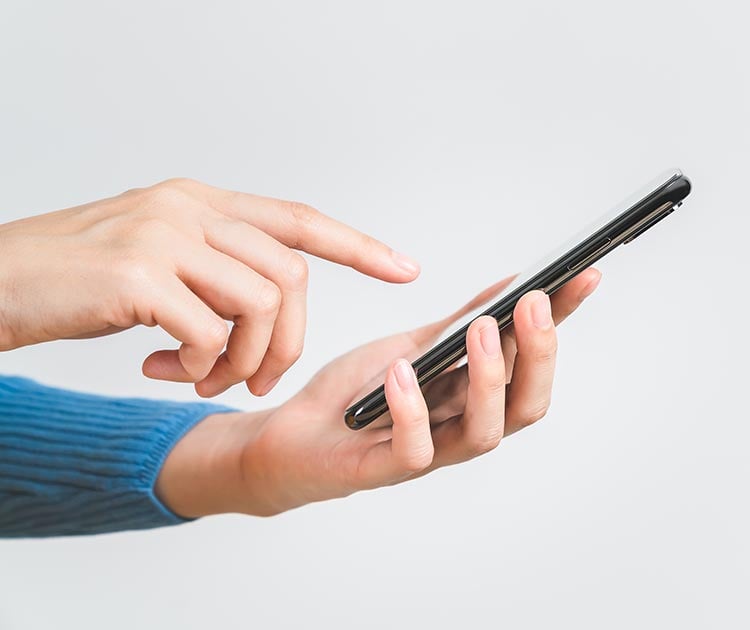 Close up photo of hands using a mobile device.