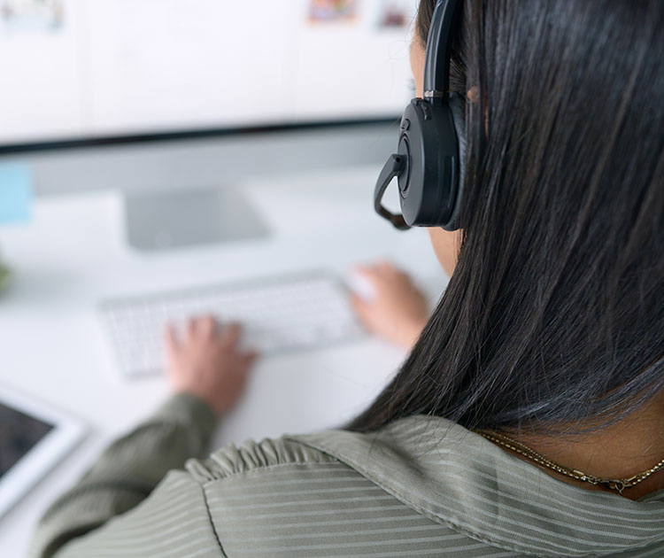 Woman with headphone at a computer.