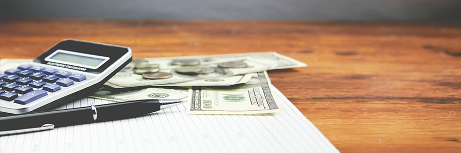 Calculator and money laying on a table.