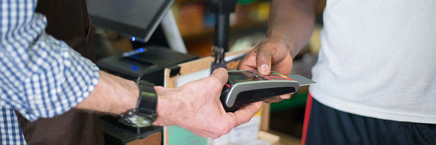 Image of a person using a retail purchase terminal conducting a transaction.