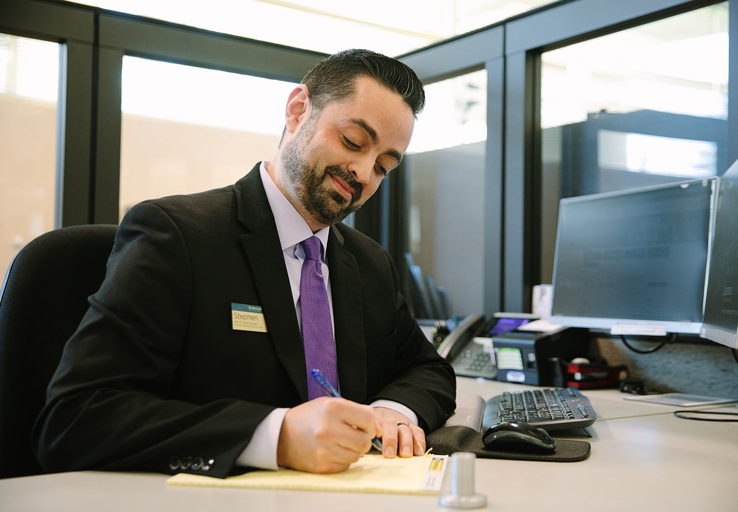 A SchoolsFirst FCU representative at a branch desk.